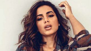 Anitta renova o bronze e deixa os seios à mostra na praia