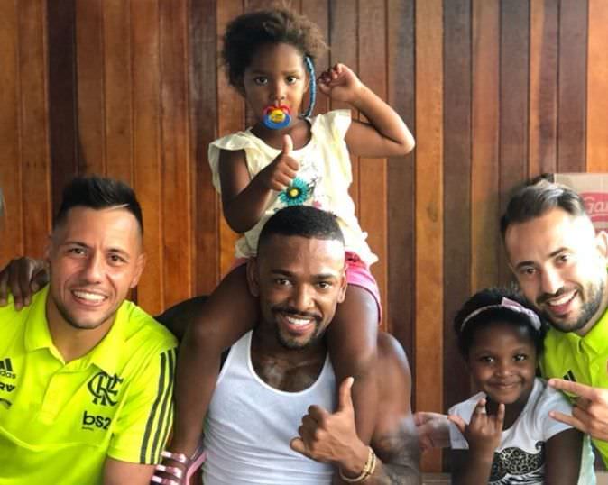 Jogadores do Fla e Nego do Borel distribuem chocolates em comunidade