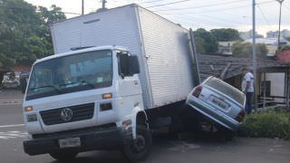 Caminhão desgovernado bate em dois carros e destrói telhado de casa