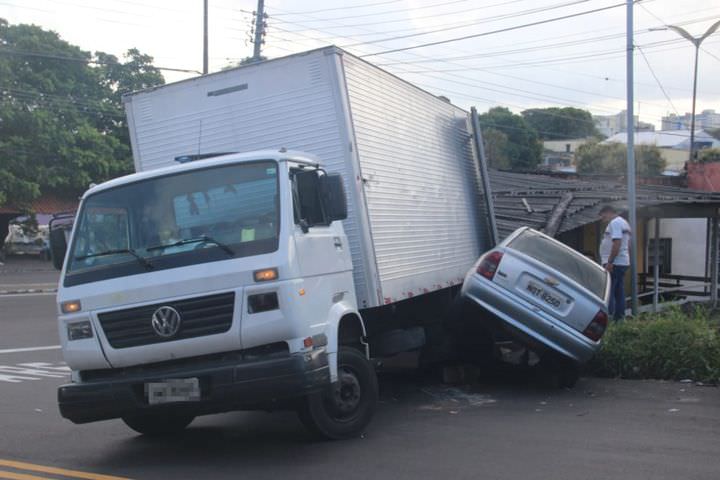 Caminhão desgovernado bate em dois carros e destrói telhado de casa