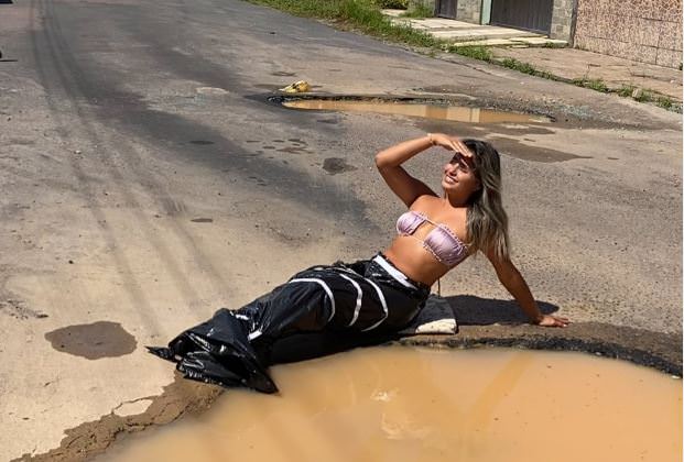 'Sereia do buraco': influenciadora inova ao cobrar asfalto em ruas de Manaus