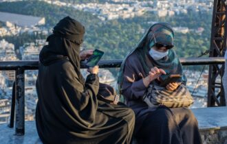 Imagem colorida mostra mulheres islâmicas usando o celular