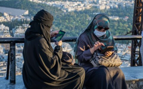 Imagem colorida mostra mulheres islâmicas usando o celular