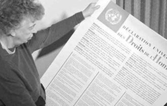 Imagem colorida mostra a diplomata e embaixadora dos Estados Unidos segurando o documento da Declaração Universal do Direitos Humanos