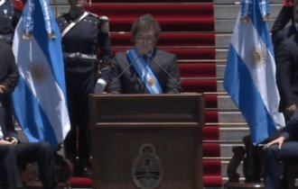 Imagem colorida mostra Milei em discurso fora do Congresso