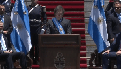 Imagem colorida mostra Milei em discurso fora do Congresso