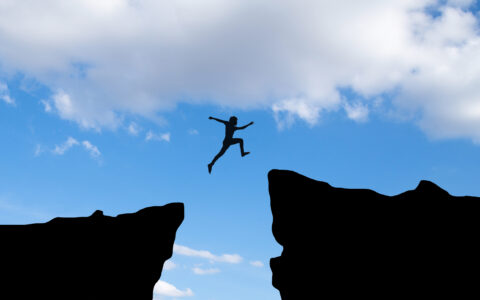 courage-man-jump-through-the-gap-between-hill-business-concept